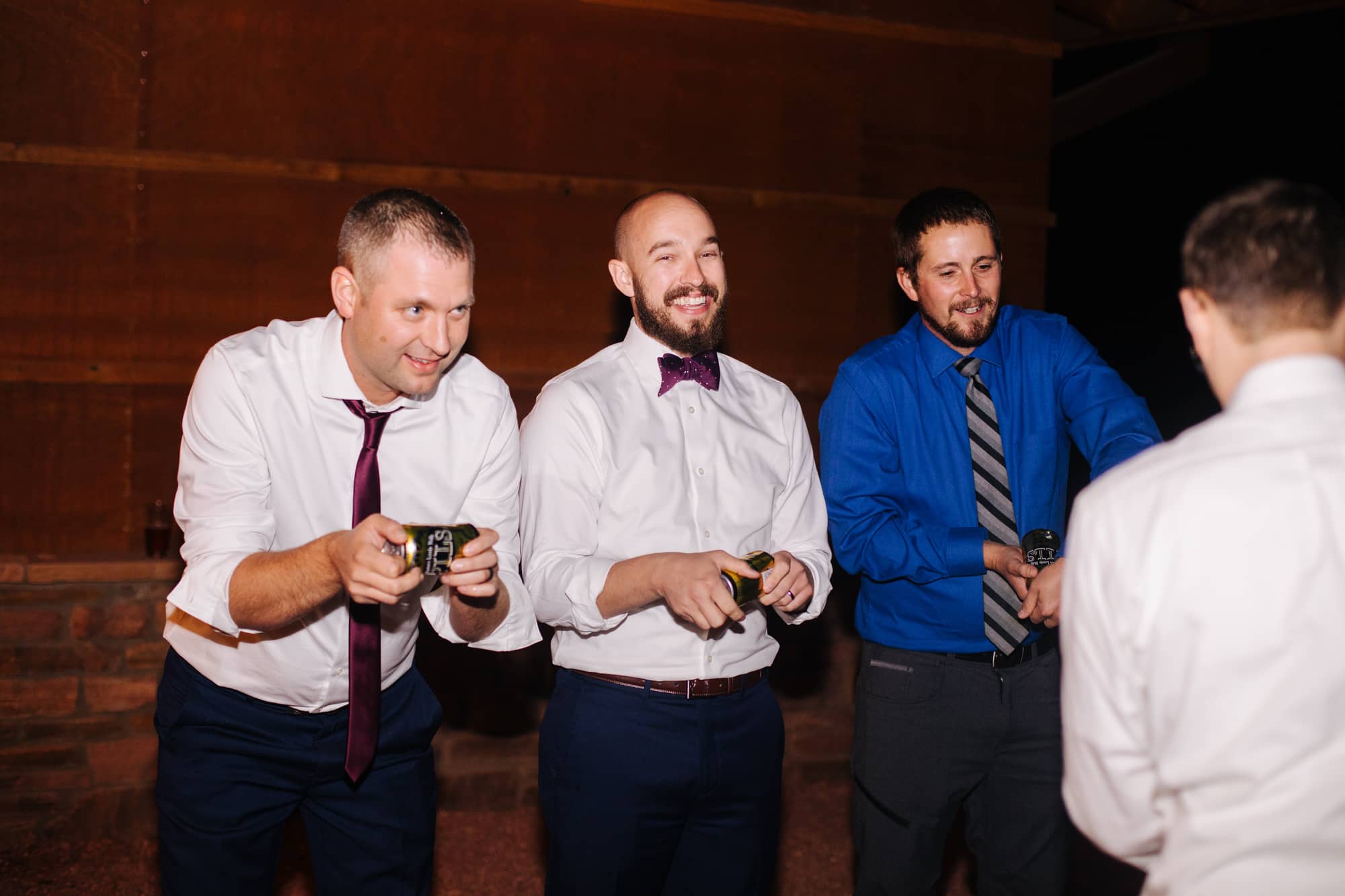 groom and groomsmen, shotgun beer at wedding, groomsmen funny photos, shotgunning beers during wedding, wedding shenanigans 