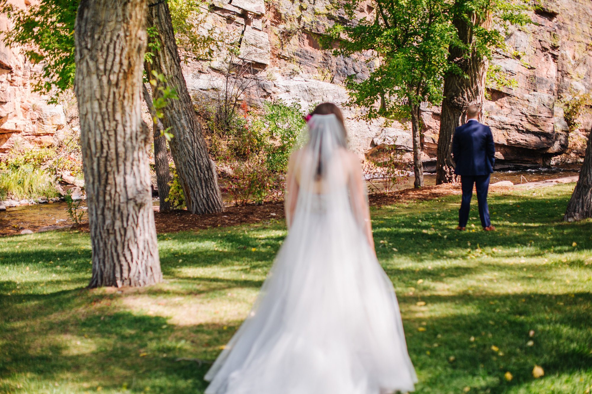 planet bluegrass, lyons colorado wedding, bride walking to first look, bride with veil, outdoor wedding, colorado wedding photographer