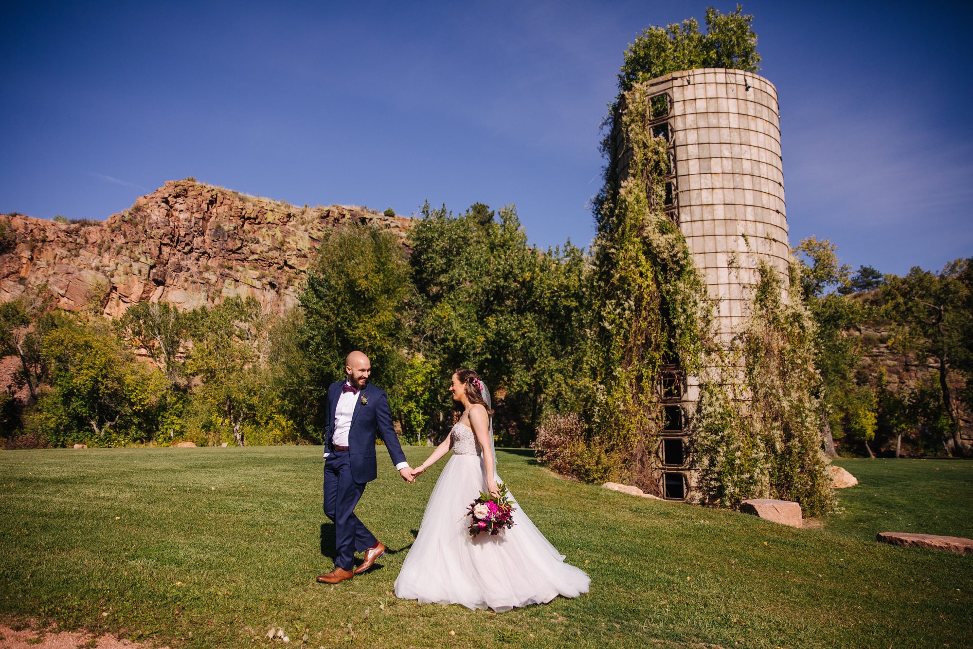 planet bluegrass wedding, lyons wedding venue, outdoor wedding venue in colorado, summer wedding, colorado wedding venue, colorado wedding photographer, summer wedding in colorado, farm wedding, bride and groom portraits, bride with veil, strapless wedding dress, blue suit groom, groom with bow tie, beaded wedding dress, colorful wedding flowers, colorful wedding photographer, silos at wedding