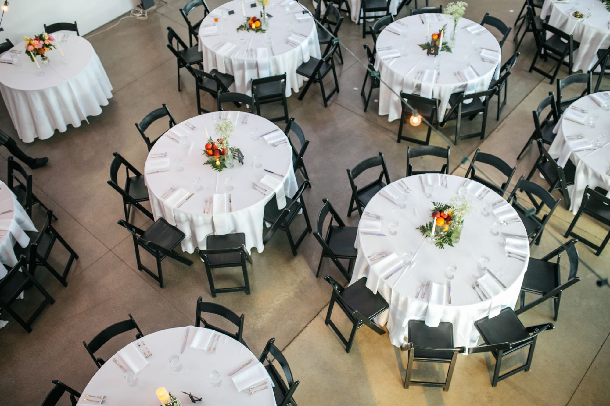 space gallery denver, indoor wedding in denver, art gallery wedding, round tables wedding, simple centerpieces at wedding, white tablecloths at wedding, black dining chairs wedding