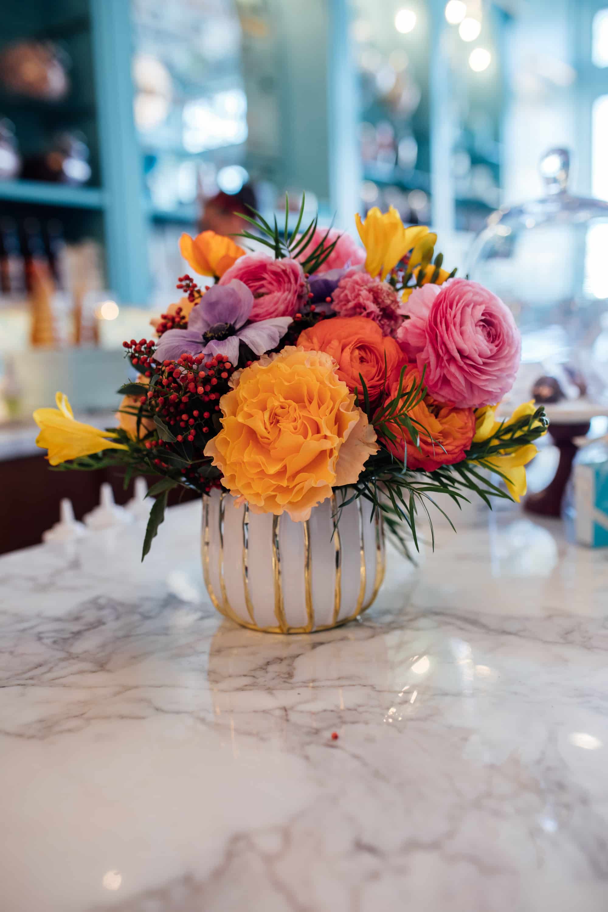 colorful wedding flowers, white and gold vase, orange and pink flowers, colorful floral ideas, marble countertop, denver wedding photographer