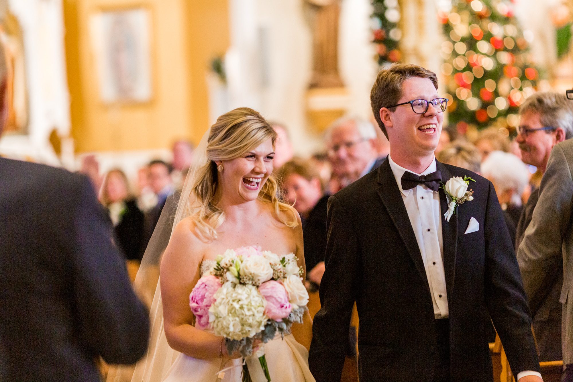 groom in glasses, groom wearing glasses, bride and groom walking down aisle, groom in tux, pink and white wedding flowers, holy ghost church denver, catholic wedding, catholic wedding denver, downtown denver church, church wedding, colorado church wedding