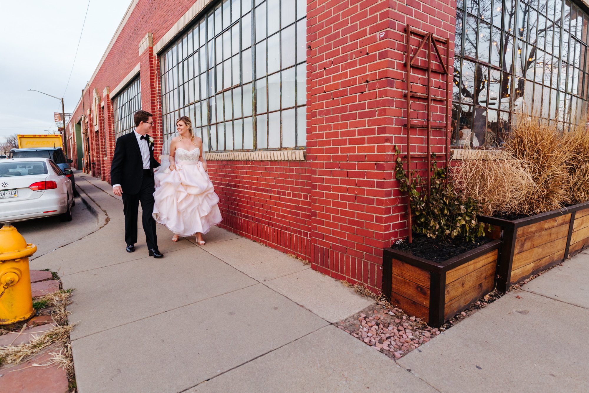 groom in tux, blush pink wedding dress, bridal veil, ruffled wedding dress, half up half down wedding hair, urban wedding, modern wedding, downtown denver wedding, moss denver, industrial wedding venue, wedding reception at moss denver, denver wedding photographer, city wedding, modern wedding venues in colorado, city venues in denver, downtown denver wedding photographer