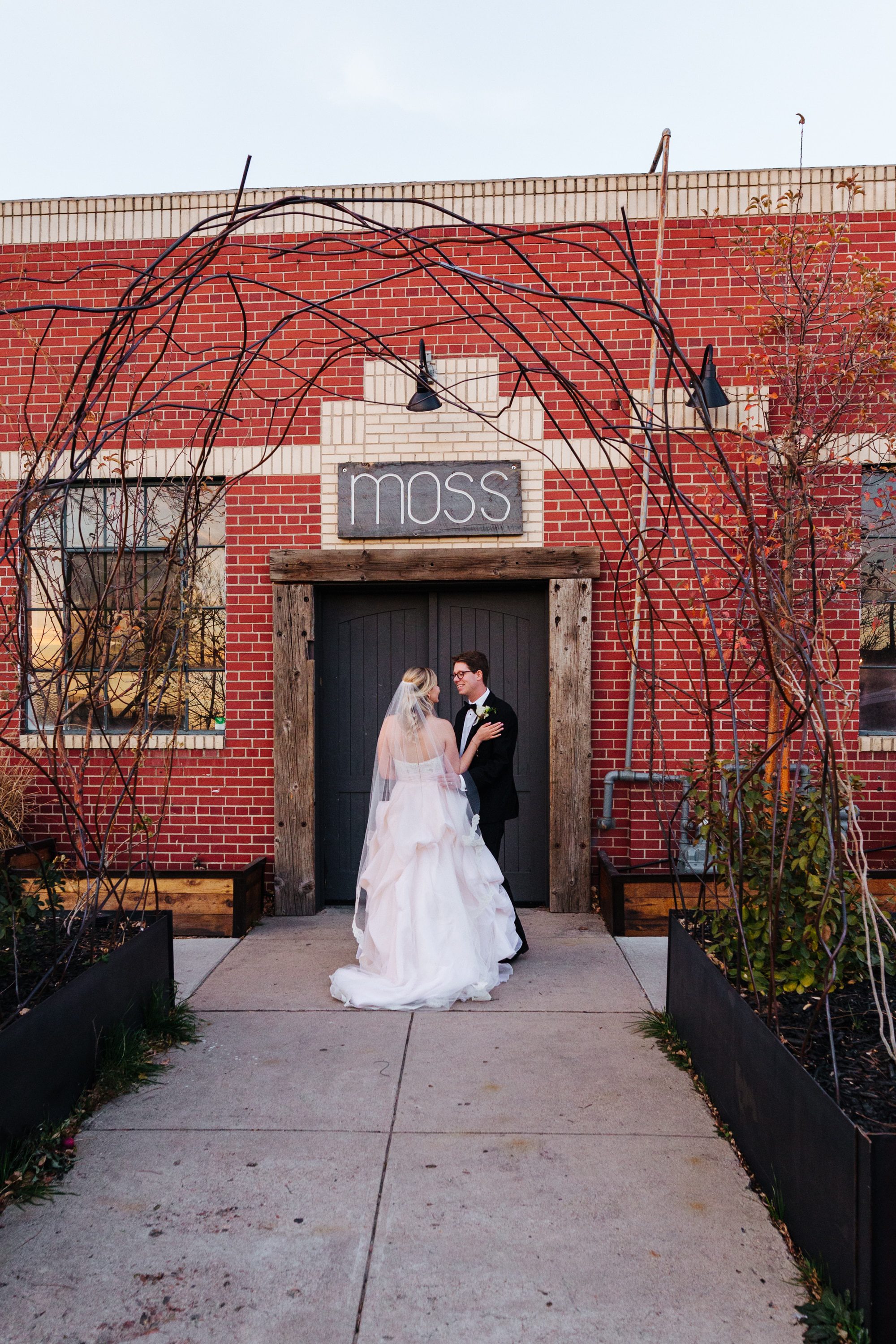 groom in tux, blush pink wedding dress, bridal veil, ruffled wedding dress, half up half down wedding hair, urban wedding, modern wedding, downtown denver wedding, moss denver, industrial wedding venue, wedding reception at moss denver, denver wedding photographer, city wedding, modern wedding venues in colorado, city venues in denver, downtown denver wedding photographer