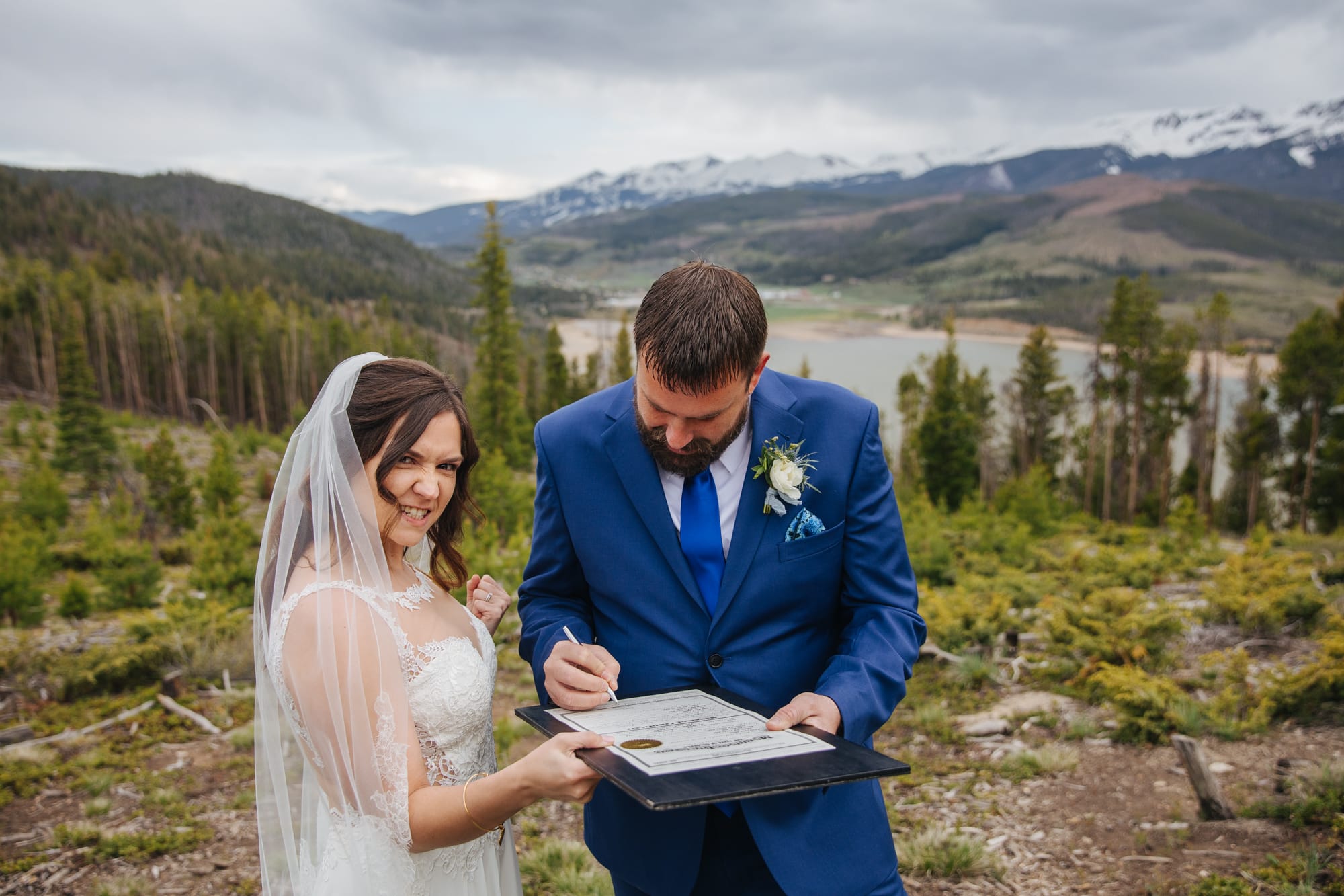sapphire point colorado, signing marriage license, marriage license signing, frisco wedding, frisco wedding photographer, colorado wedding photographer, intimate wedding, scenic wedding, mountain wedding, bride celebrating after ceremony, groom signing marriage license, funny wedding photos