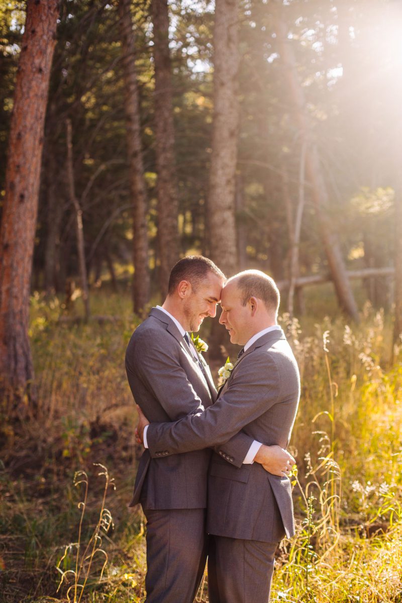 the pines at Genesee, the pines at Genesee venue, lgbt, two grooms, lgbtq, lgbt photographer, denver lgbt photographer, denver photographer, best photographers in denver, lgbt engagement photographer, denver lgbt engagement photographer, lgbt vendors, denver gay marriage, first look, two grooms embrace, Colorado wedding photographer, LGBT wedding photographer in Denver, LGBT wedding photographer in Colorado, matching boutonnieres, couples portraits in field, posing same sex couples