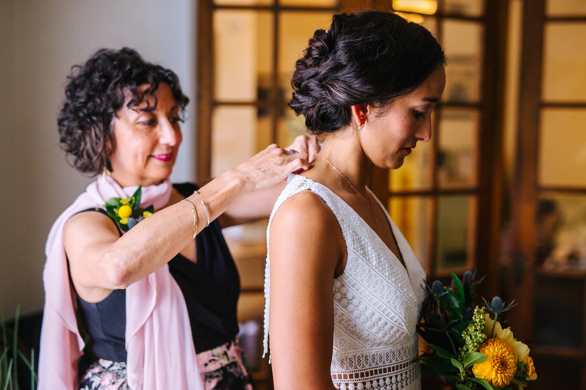 bride with mom, bride getting ready with mom, mom helping bride into dress