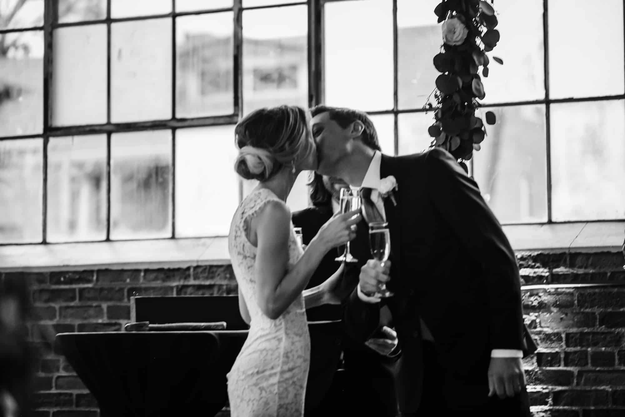 bride and groom first kiss, black and white first kiss, now pronounce husband and wife, champagne during ceremony
