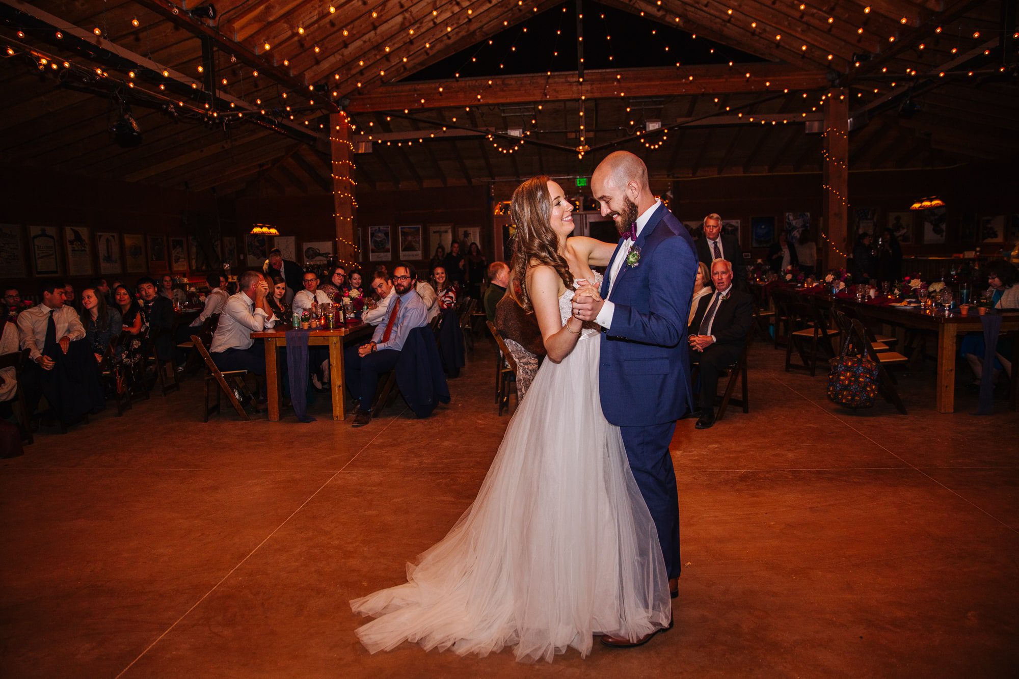 indoor wedding reception, planet bluegrass wedding, planet bluegrass reception, barn wedding, colorado wedding venue, bride and groom first dance, blue suit groom