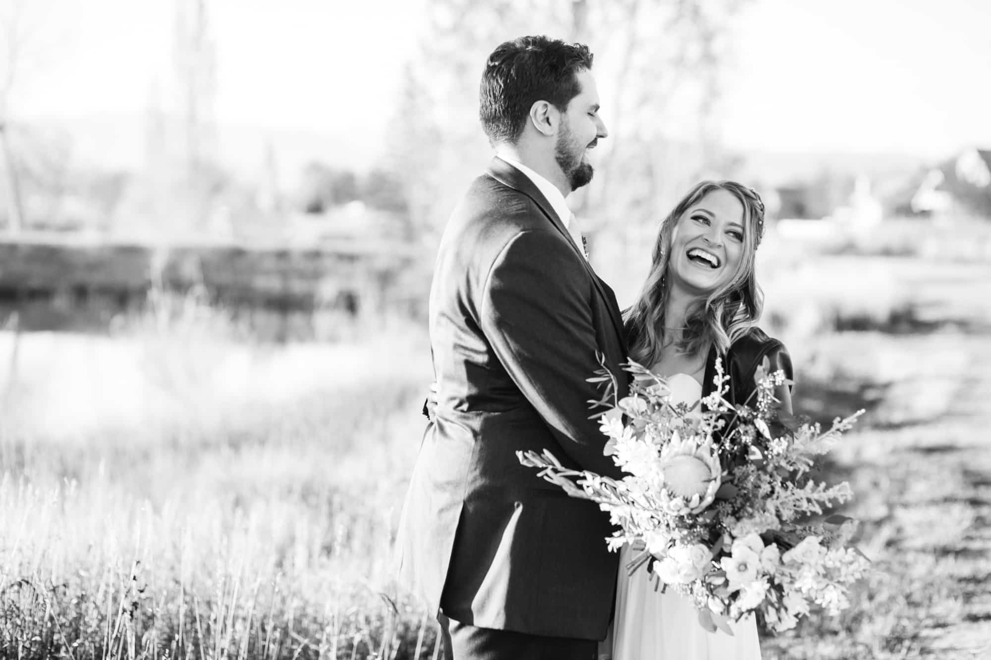 black and white wedding, bride and groom, bride laughing, large flowers, large wedding bouquet, bride in leather jacket