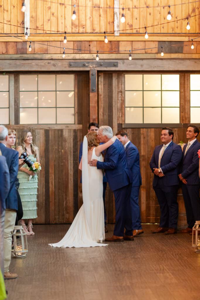 bride hugging dad, bride hugging father, hugs at weddings, seattle industrial wedding venue, downtown seattle wedding venue, sodo park seattle wedding ceremony, sodo park seattle herban feast, sodo park seattle 