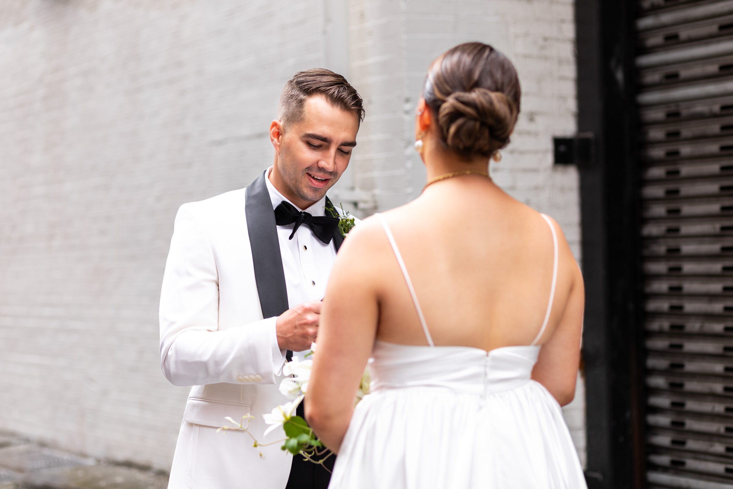 Bride and groom, during first look and private vows in elegant black tie, wedding outside of the Alexis Hotel