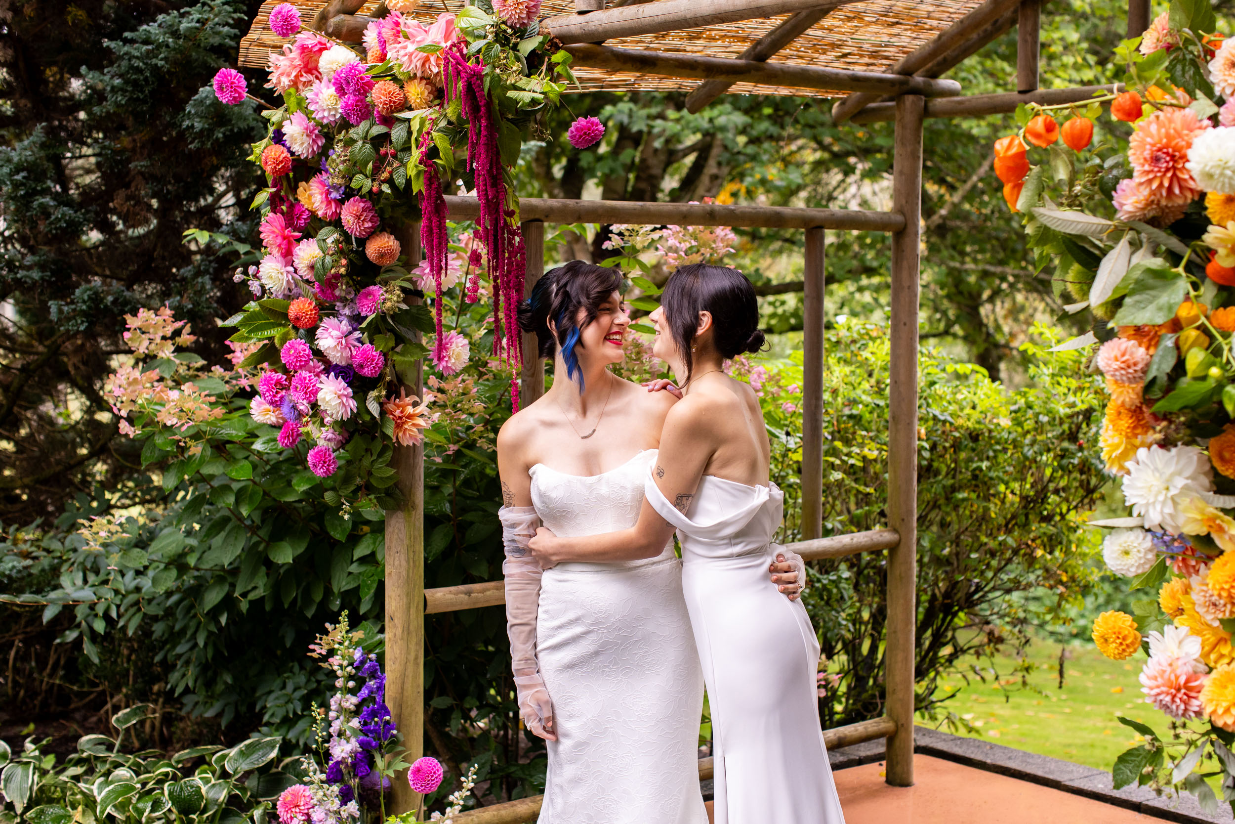 Two brides kissing during colorful queer wedding ceremony in Seattle