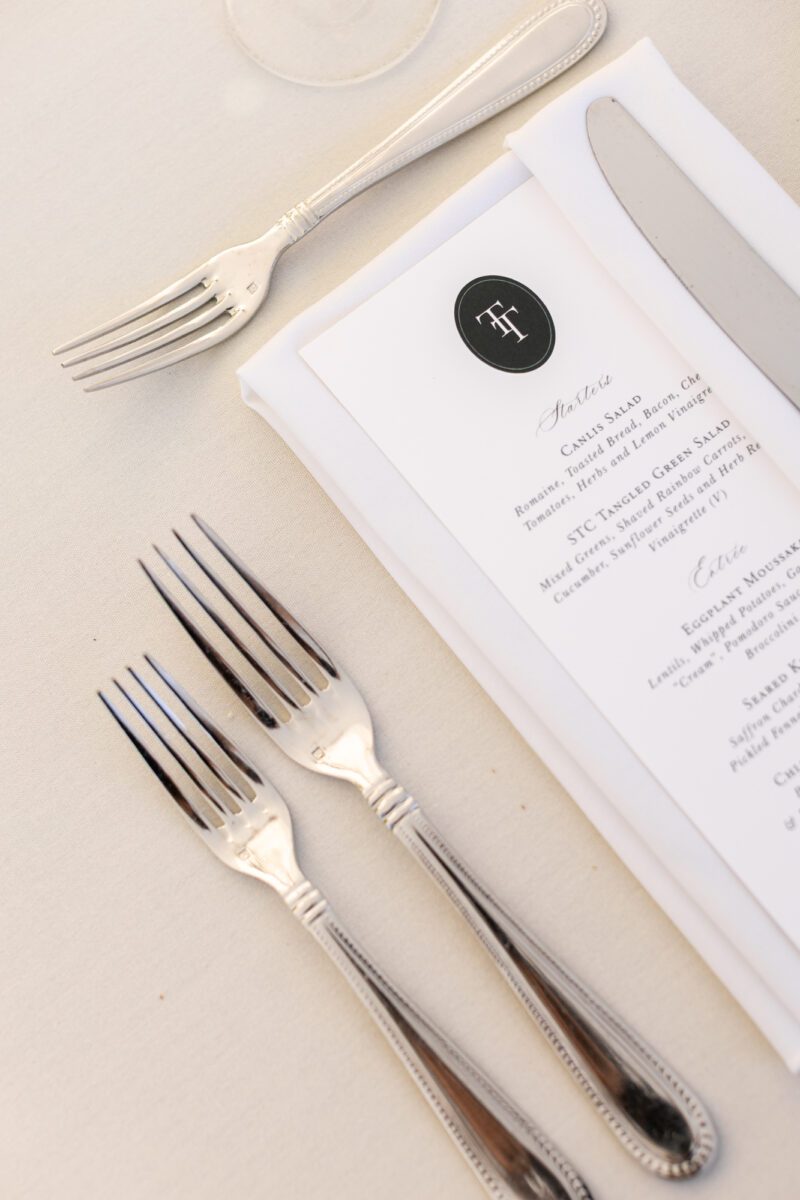 Wedding dinner menu with forks on white tablecloth