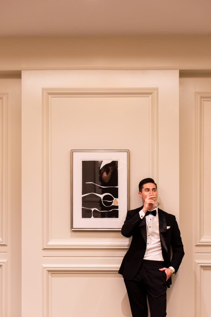 Groom drinking champagne during getting ready photos for groomsmen in Seattle.