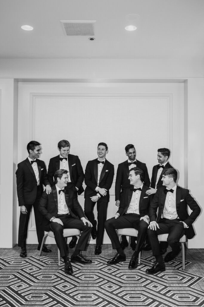 Black and white photo of groomsmen hanging out during getting ready before their Seattle wedding.