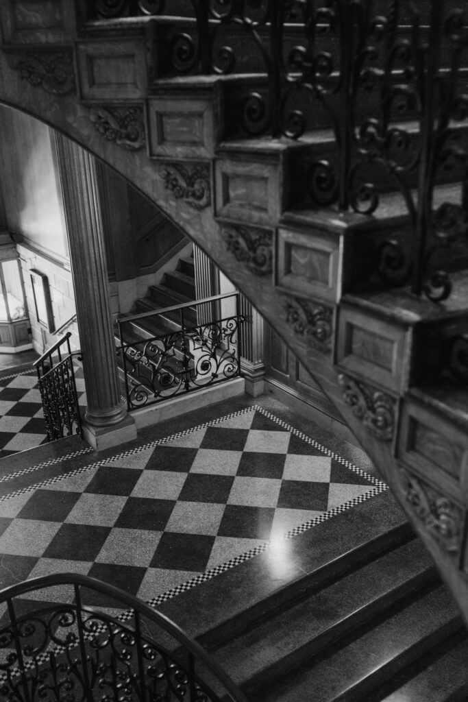 Black and white photo of stairway and checkered floor in the vintage luxury hotel in downtown Seattle.