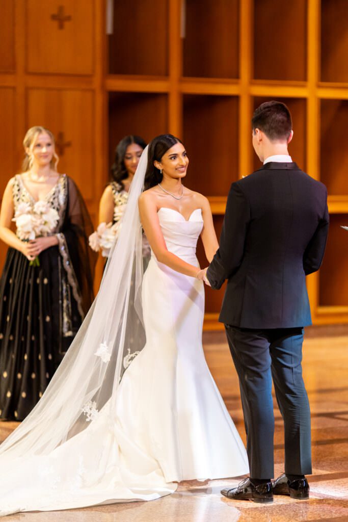 Bride and groom holding hands looking at each other during intimate church ceremony in Seattle at Bastyr Chapel