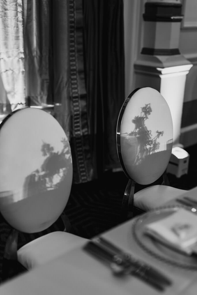 Black and white close up photo of the beautiful wedding reception chairs with the shadows of flowers during luxury wedding at the Fairmont Olympic Hotel Seattle.