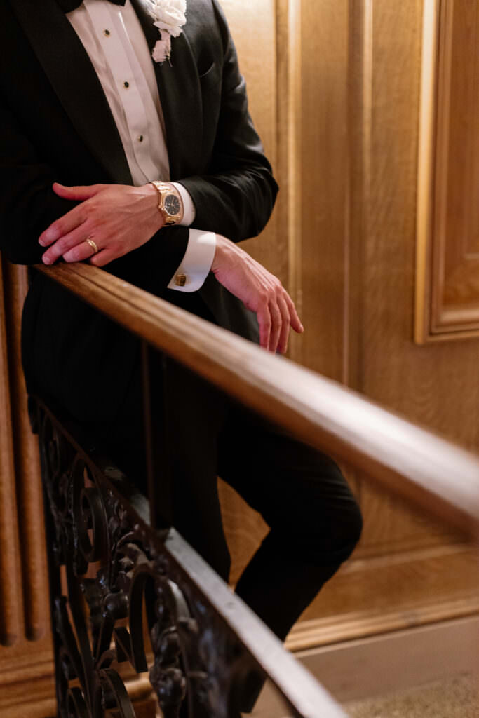 Close up photo of groom on railing during couples portraits during luxury hotel downtown Seattle wedding