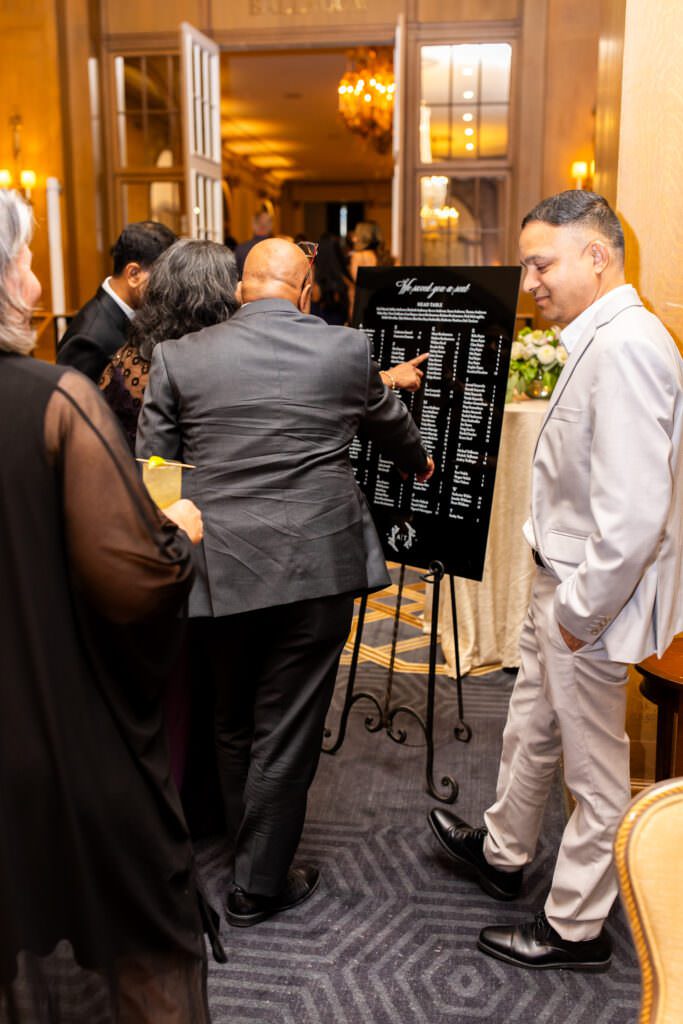 Guests looking at wedding table chart before reception at Fairmont Olympic Hotel in downtown Seattle.