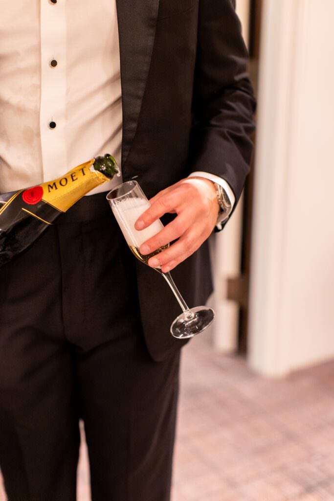 Groom pouring champagne during getting ready photos during Seattle wedding
