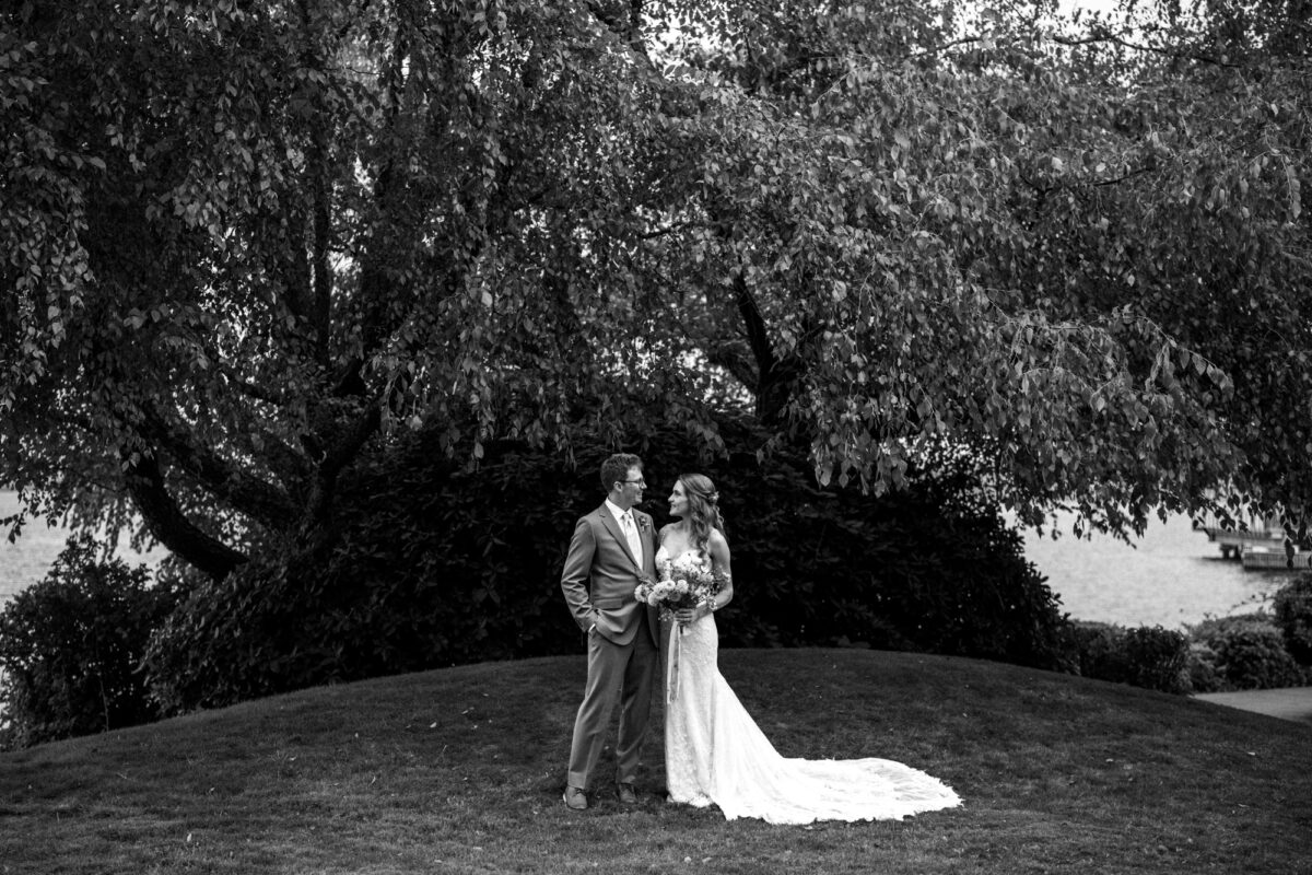 Bride and groom Portraits on Lake Washington at the Woodmark hotel and still spot in Kirkland. Groom, sage, green suit, yellow, and orange wedding flowers.