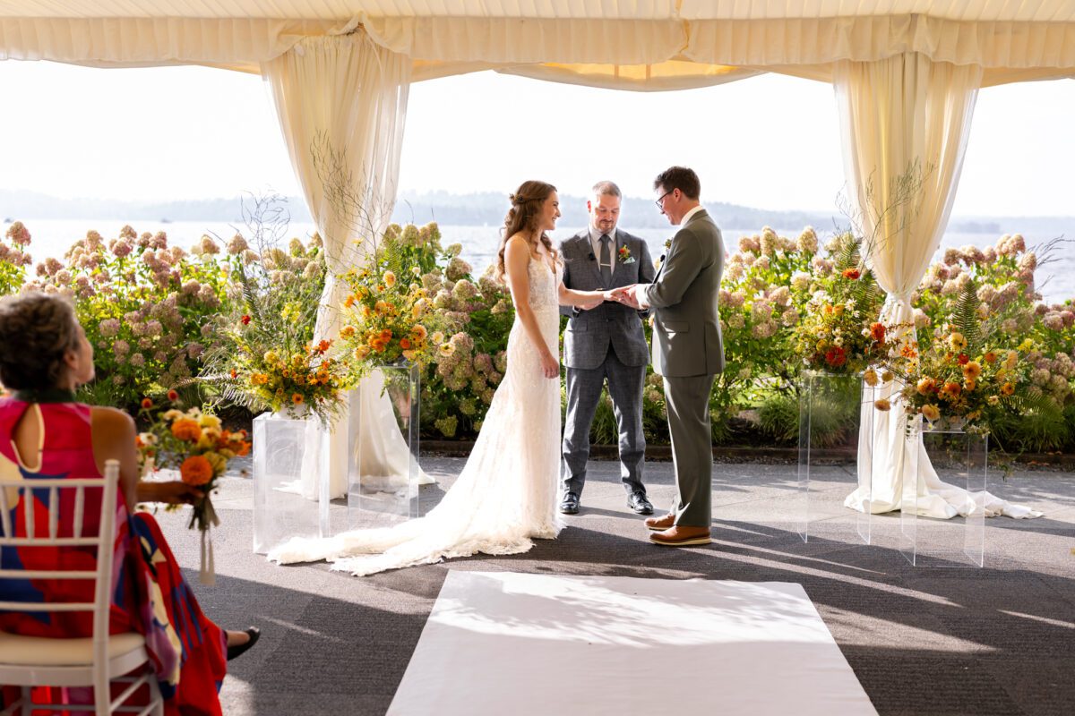 Bride and groom during outdoor tent, wedding ceremony at the Woodmark hotel, and still spa on Lake Washington
