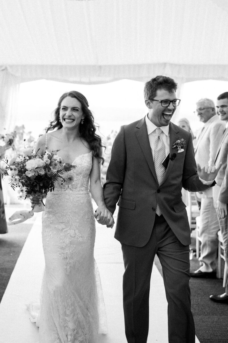 Bride and groom during outdoor tent, wedding ceremony at the Woodmark hotel, and still spa on Lake Washington, exiting ceremony