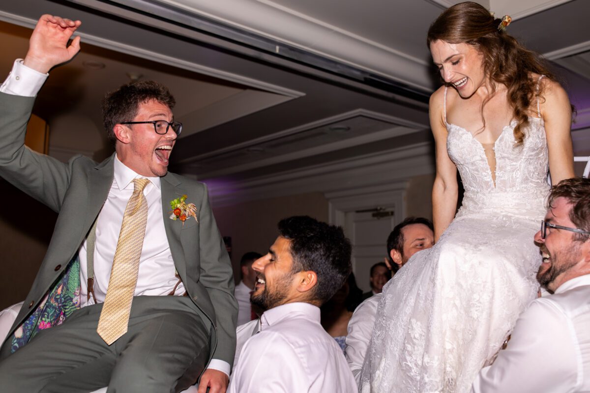 Bride and groom being hoisted in the air for the horah dance during their wedding