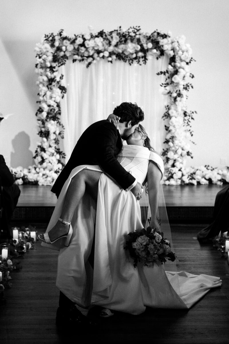 bride and groom dip kiss recession during ceremony at indoor wedding ceremony in Bellingham, Chuckanut Bay Distillery wedding