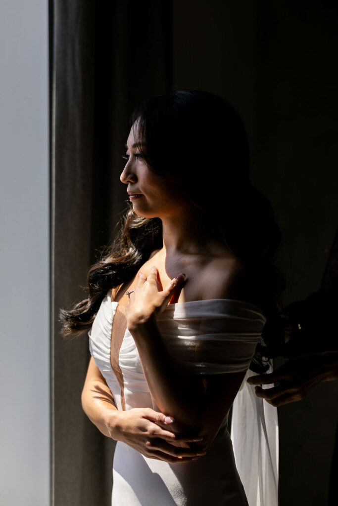 bride stands in window light