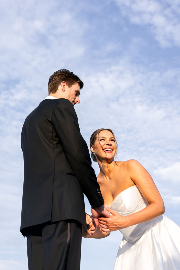 Bride smiling while holding hands with the groom during couples portraits at Alderbrook Resort and Spa