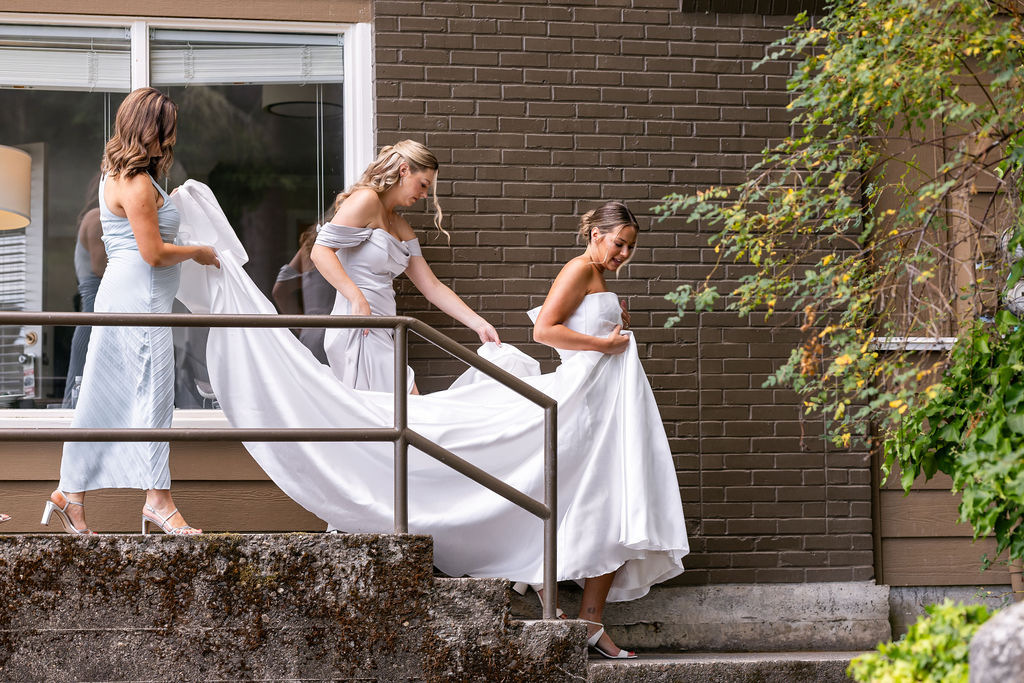 bride gets help walking down stairs