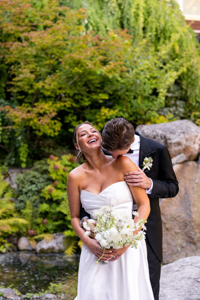 groom kisses brides neck during black tie Alderbrook Resort summer wedding