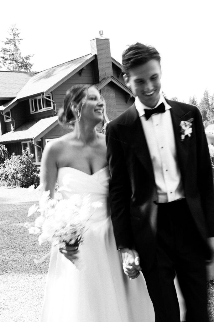 Black and white image of bride and groom walking together during Alderbrook Resort wedding