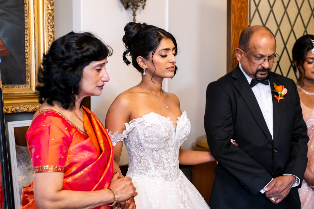 Bride praying with parents before indian catholic wedding church ceremony in seattle