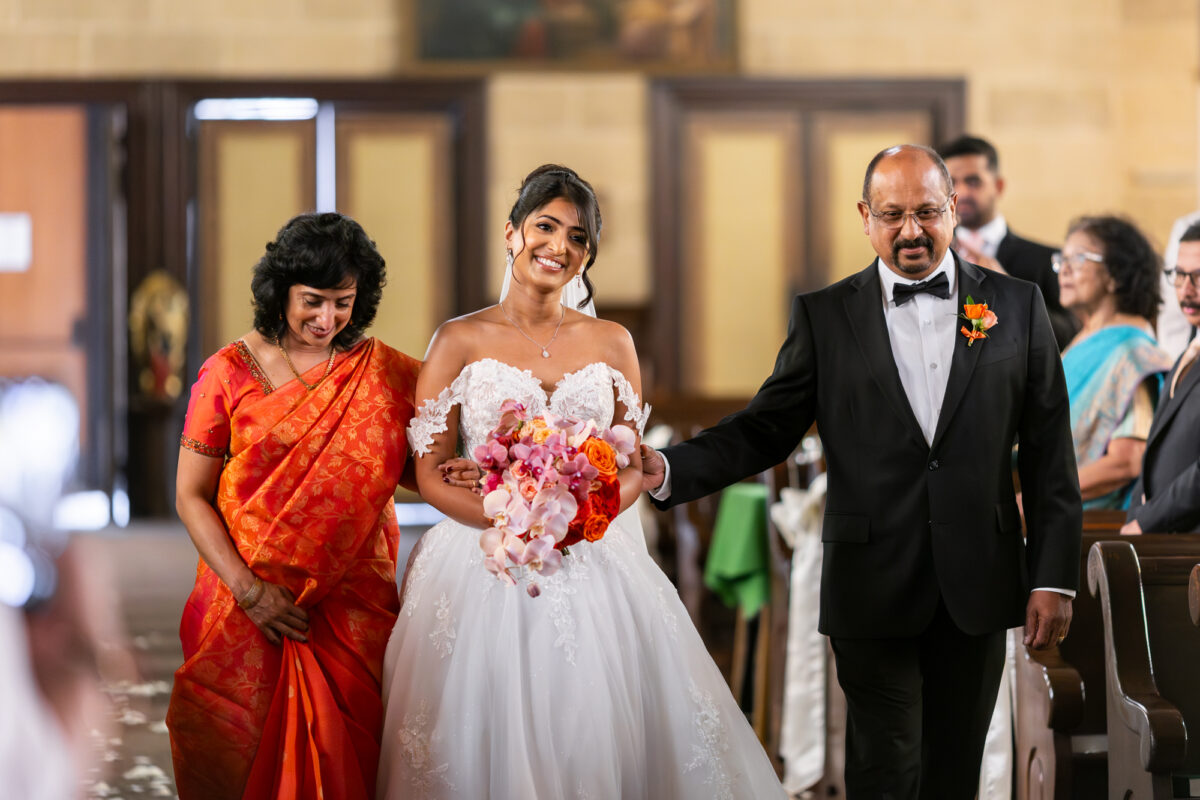 Bride walking down aisle to husband at Immaculate Conception in Seattle
