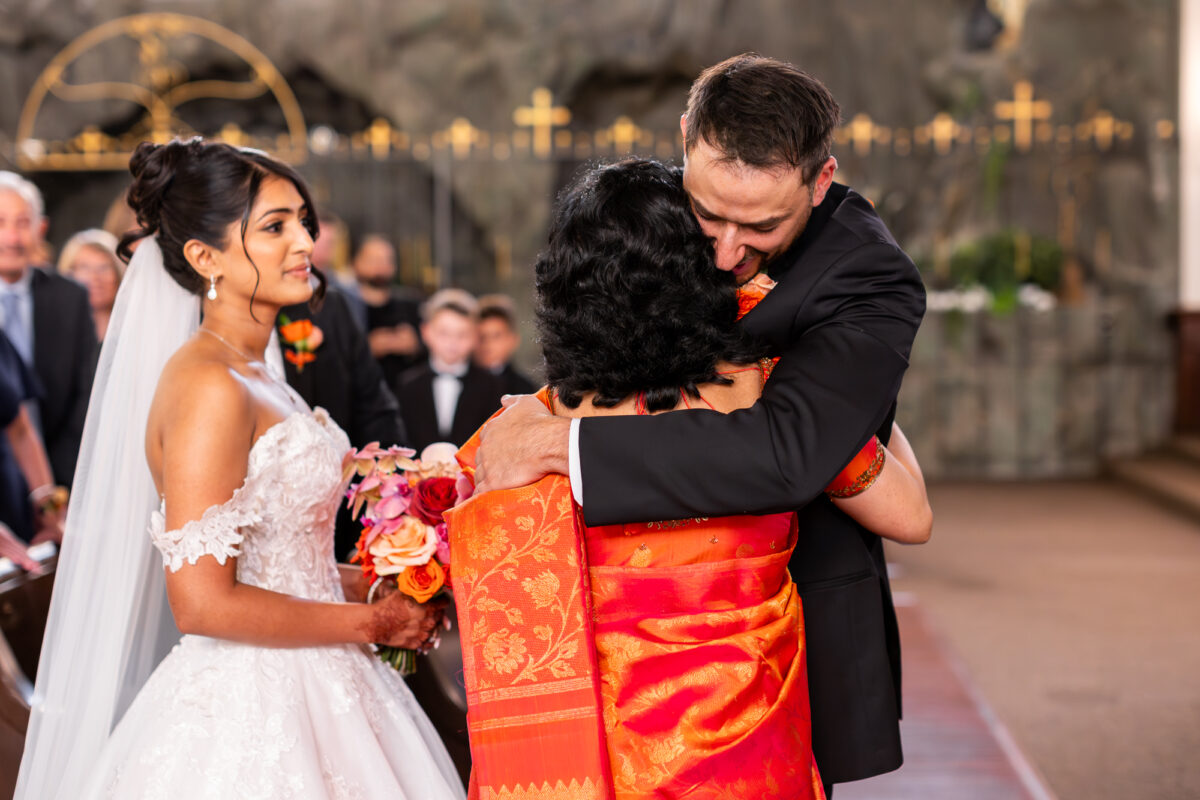 Groom hugging bride's mom in catholic church ceremony seattle