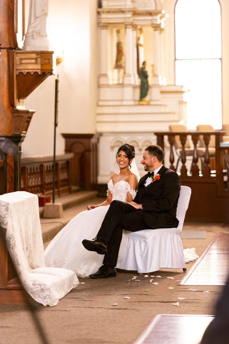 bride and groom sitting during catholic church wedding at immaculate conception seattle