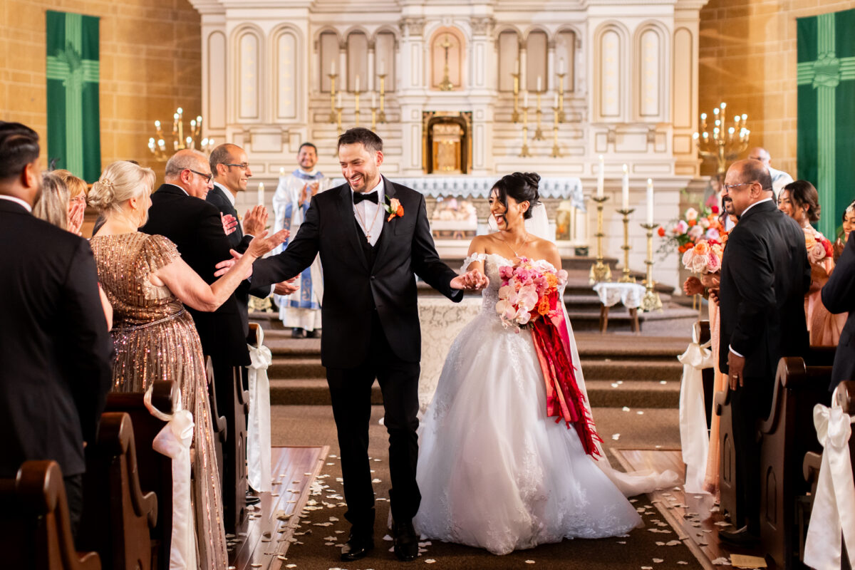 Bride and groom after getting married walking down aisle at immaculate conception seattle
