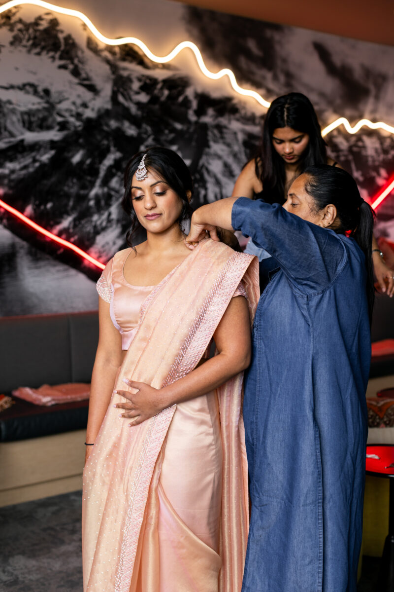 Bridesmaid getting into sari for Seattle Indian wedding