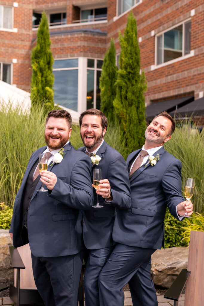 Groomsmen with champagne posing and laughing