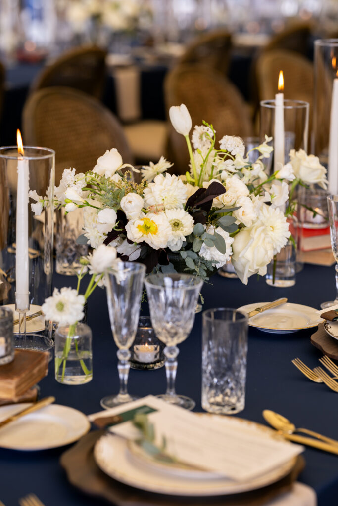Blue tablecloth with white candles and white florals 