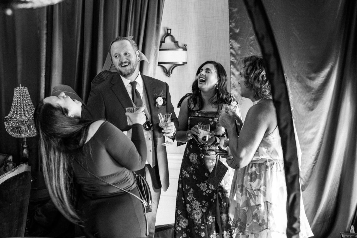Groom laughing with guests before dinner