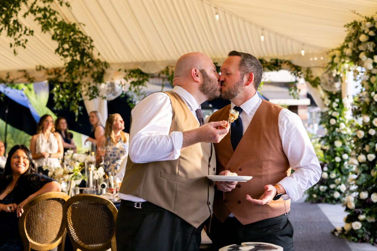 Grooms kissing after cake cutting