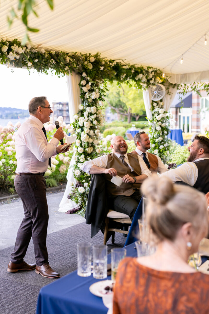 Father of groom giving speech under tent