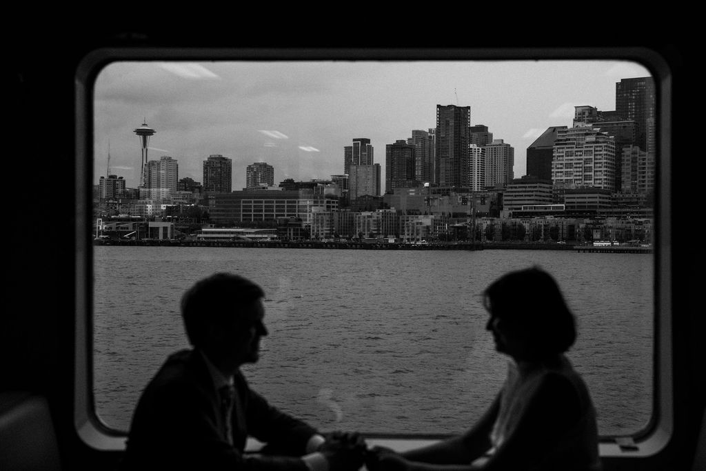 bride and groom on ferry with seattle in background